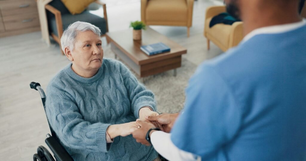 Wheelchair, happy or old woman holding hands with nurse for support or empathy for healthcare servi